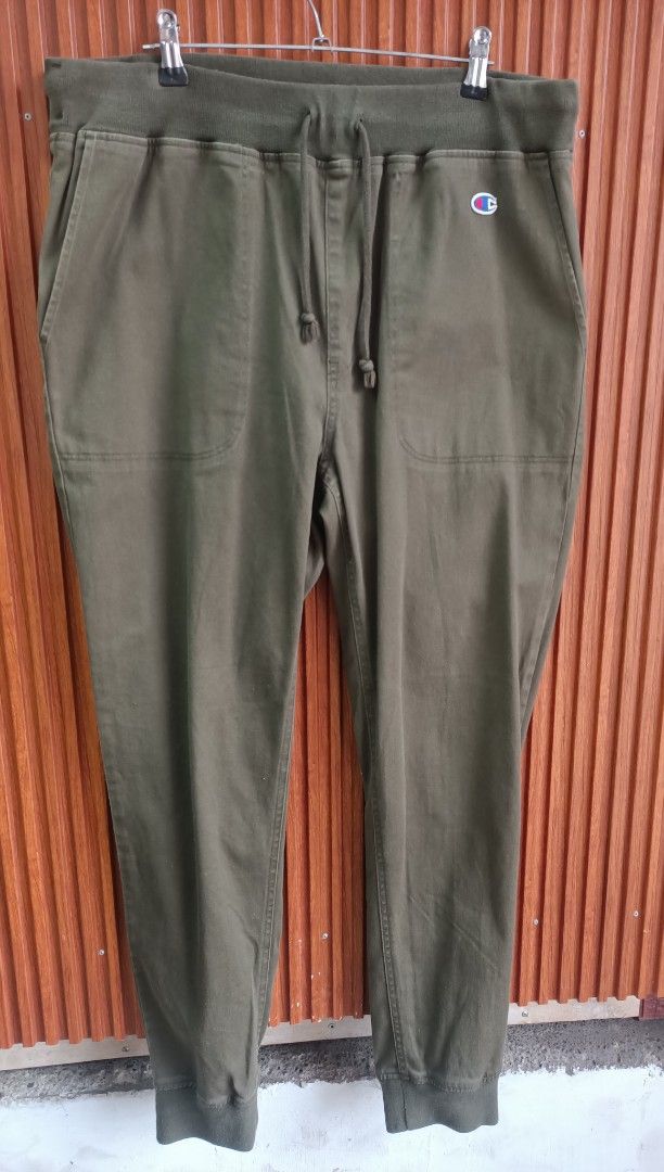 Champion Green Jogger Pants Size L (Category: Joggers) located in Bayombong. Submitted by rheaaa00530 (Listing ID 1469685271, Image 1). Description: - Brand: Champion - Color: Olive Green - Size: Large - Condition: Great casual wear - Waistband: Elastic with matching drawstring cords - Pockets: Deep front pockets - Details: Small embroidered Champion logo patch on the left thigh - Cuffs: Ribbed at the ankles - Ideal for: Lounging or running erran