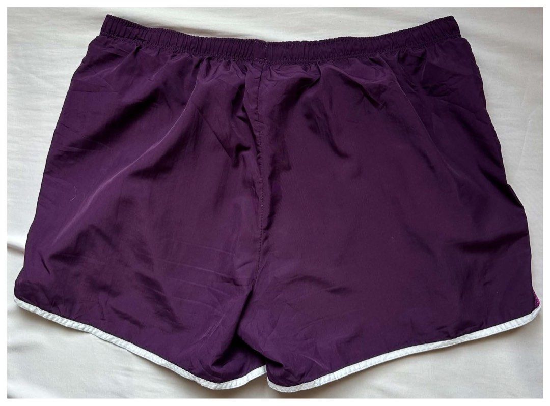 Champion Running Shorts Medium Purple Pink (Category: Activewear) located in Cebu City. Submitted by purgemycloset (Listing ID 1469650184, Image 2). Description: - Brand: Champion - Style: Athletic running shorts - Color: Dark purple with vibrant pink side panels and white piping - Size: Medium (M) - Features: Comfortable elastic waistband, embroidered logo near lower left hem - Material: Lightweight fabric - Ideal for: Workouts, running, or casu