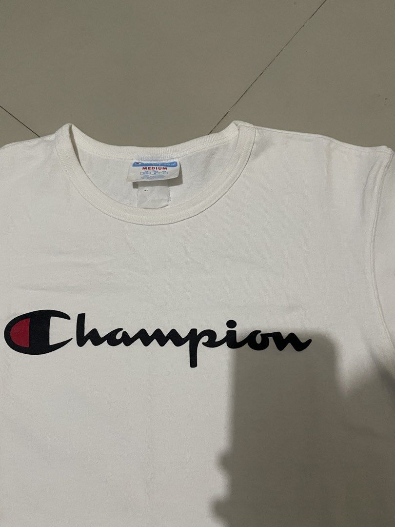 Champion White Script Logo T-Shirt (Category: Tshirts & Polo Shirts ) located in Mabalacat. Submitted by cornistaja55233 (Listing ID 1469732911, Image 2). Description: Champion Script Logo Size M on Tag W: 19 L: 27 Cr: 10/10 Overall Condition: 9.5/10 Price: 299 + Shipping Fee.