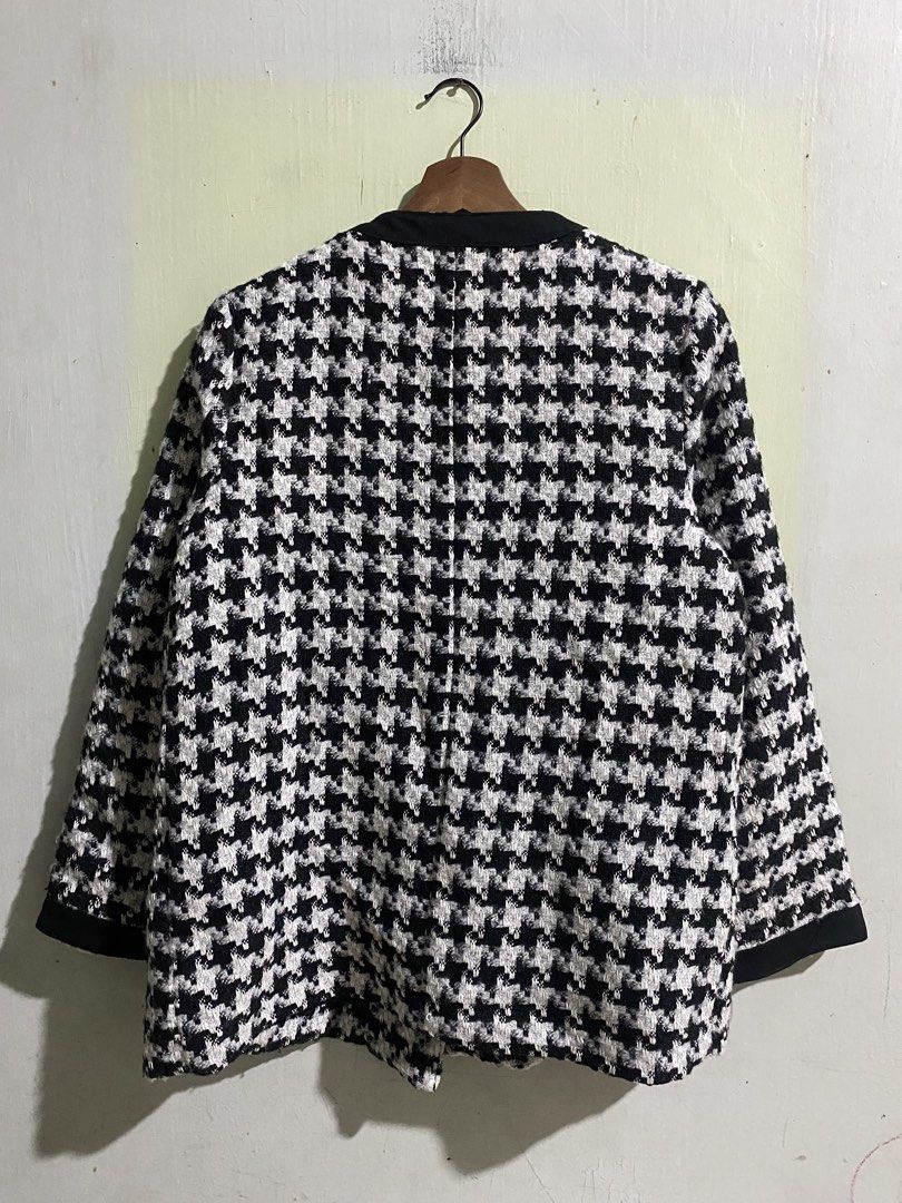 Chanel Black and White Houndstooth Tweed Jacket (Category: Coats, Jackets and Outerwear) located in Pandi. Submitted by nasya_thrift_collection2023 (Listing ID 1469716891, Image 3). Description: - Style: Classic black and white houndstooth tweed jacket - Design: Structured collarless fit with elegant contrasting black trim - Details: Two front patch pockets and front button closure - Lining: Fully lined in black fabric with Chanel brand label - V