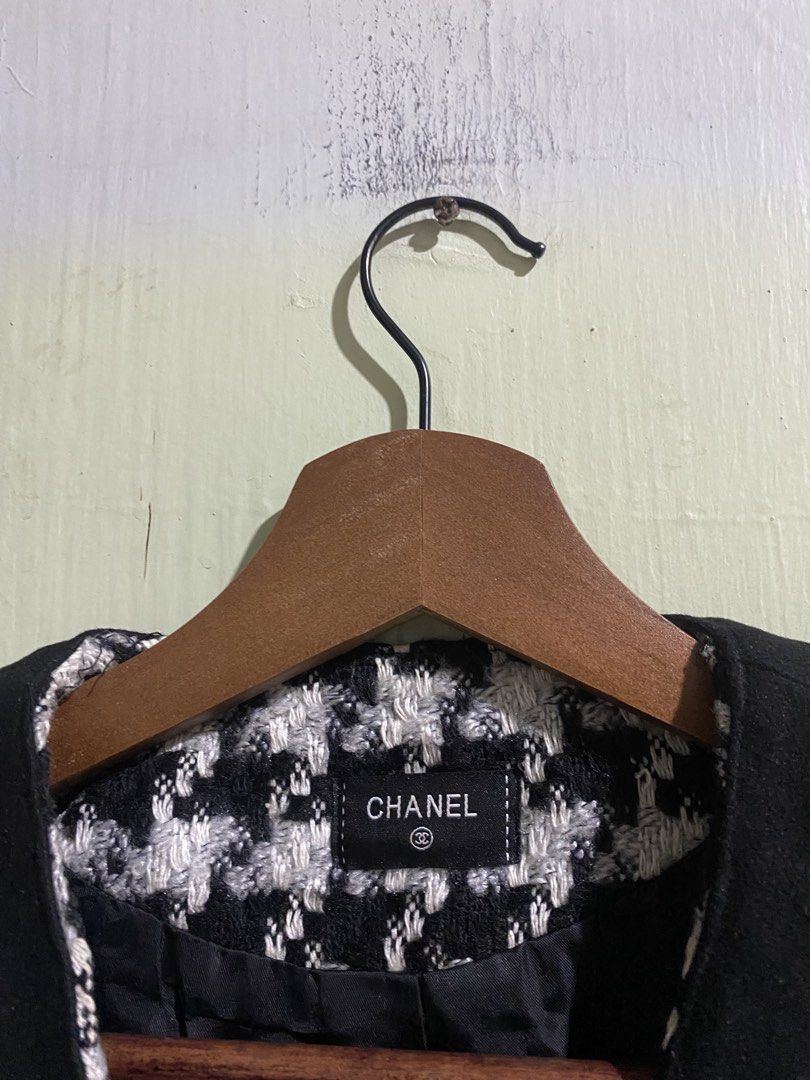 Chanel Black and White Houndstooth Tweed Jacket (Category: Coats, Jackets and Outerwear) located in Pandi. Submitted by nasya_thrift_collection2023 (Listing ID 1469716891, Image 2). Description: - Style: Classic black and white houndstooth tweed jacket - Design: Structured collarless fit with elegant contrasting black trim - Details: Two front patch pockets and front button closure - Lining: Fully lined in black fabric with Chanel brand label - V