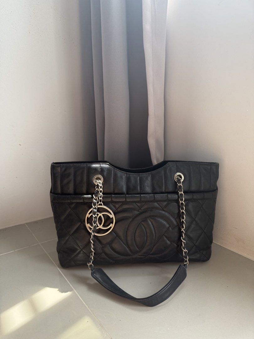 Chanel Black Leather Tote Bag with CC Charm (Category: Luxury Bags & Wallets) located in Quezon City. Submitted by luxurybags.ph_official2017 (Listing ID 1469712516, Image 3). Description: - Brand: Chanel Tote - Material: Premium black leather - Design: Quilted body with smooth top panel - Details: Large stitched CC logo on front & dangling silver CC charm - Straps: Metal chain straps with comfortable leather shoulder guards - Interior: Roomy and