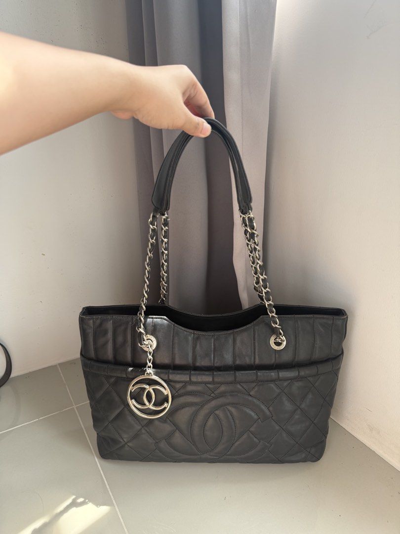 Chanel Black Leather Tote Bag with CC Charm (Category: Luxury Bags & Wallets) located in Quezon City. Submitted by luxurybags.ph_official2017 (Listing ID 1469712516, Image 2). Description: - Brand: Chanel Tote - Material: Premium black leather - Design: Quilted body with smooth top panel - Details: Large stitched CC logo on front & dangling silver CC charm - Straps: Metal chain straps with comfortable leather shoulder guards - Interior: Roomy and