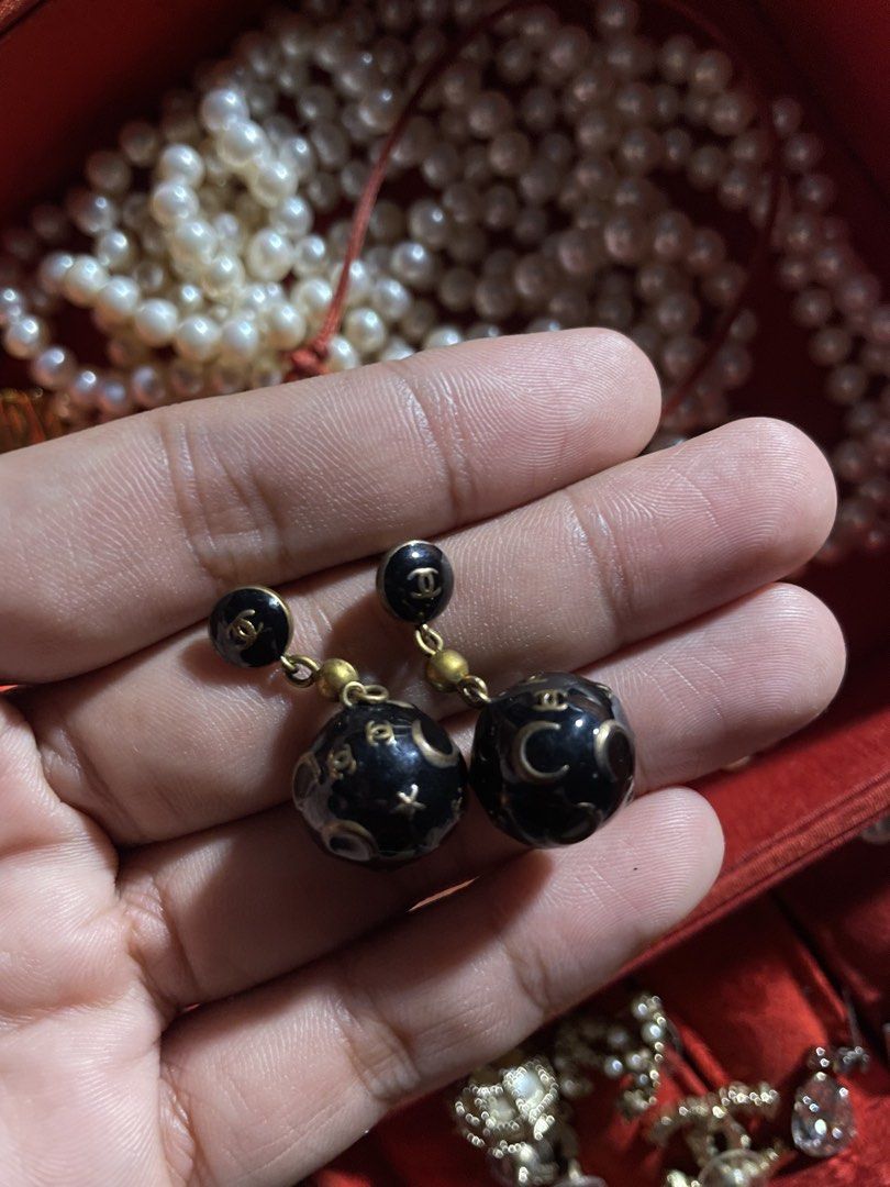 Chanel Earrings (Category: Luxury Accessories) located in Dumaguete. Submitted by jaymharr (Listing ID 1469694331, Image 3). Description: Chanel Star and Moon Resin Sphere Drop Earrings. This celestial-themed vintage costume jewelry design features black round studs detailed with the signature interlocking gold CC logo. Suspended below are large black resin orbs adorned with gold inlaid crescent moons, stars, and tiny dotted constellations..