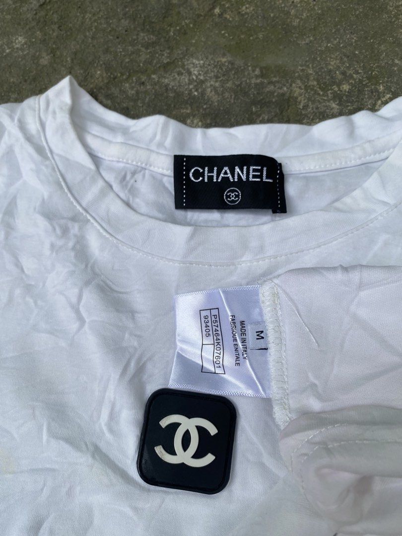 Chanel White Black Stripe Logo T-Shirt Medium (Category: Shirts) located in Abulug. Submitted by axeldot (Listing ID 1469653508, Image 2). Description: - Brand: Chanel - Color: White with black side stripes - Material: 100% cotton, Made in Italy - Size: Medium - Features: Black square logo patch on chest and matching inner collar brand tag - Flaws: Minor yellowish stains on lower front and some wear on the chest patch.