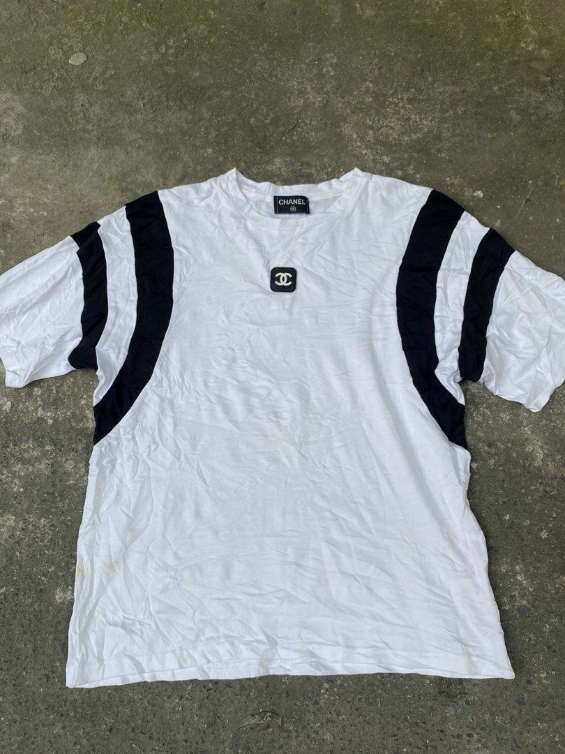 Chanel White Black Stripe Logo T-Shirt Medium (Category: Shirts) located in Abulug. Submitted by axeldot (Listing ID 1469653508, Image 1). Description: - Brand: Chanel - Color: White with black side stripes - Material: 100% cotton, Made in Italy - Size: Medium - Features: Black square logo patch on chest and matching inner collar brand tag - Flaws: Minor yellowish stains on lower front and some wear on the chest patch.