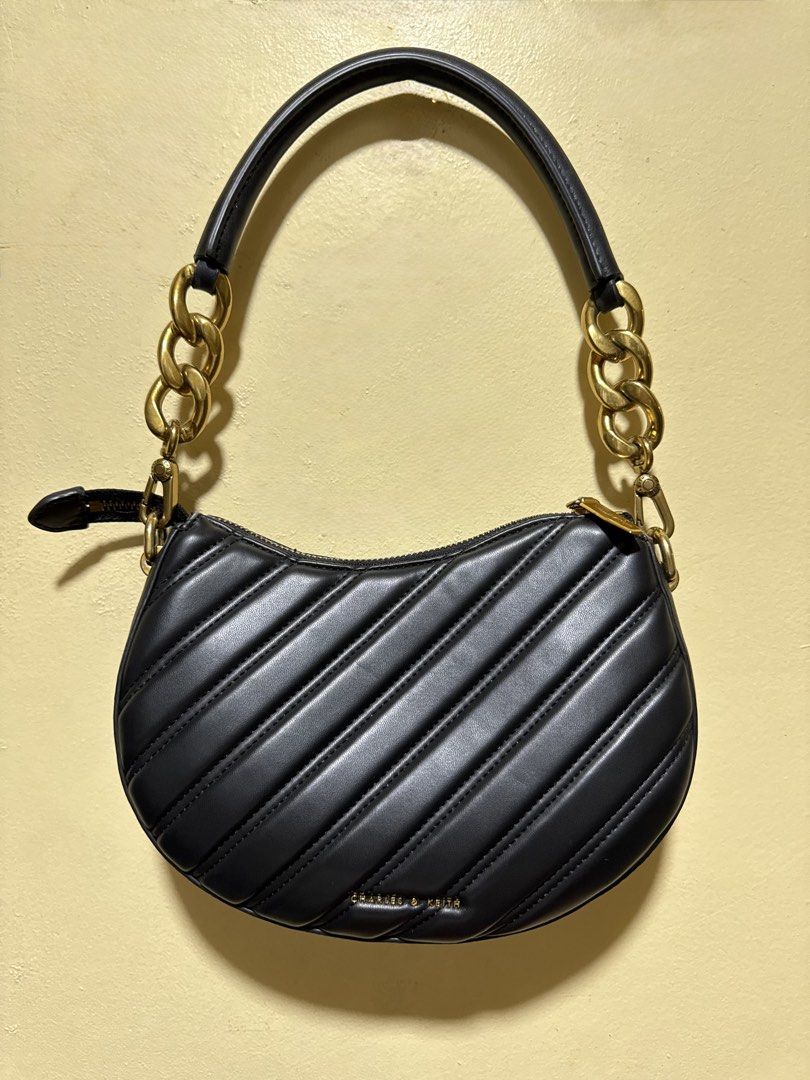 Charles & Keith (Category: Luxury Bags & Wallets) located in Taguig. Submitted by pepperonia_01 (Listing ID 1469588288, Image 1). Description: Charles & Keith Freja Curved Panelled Bag Like new Product Details -curved silhouette and panelled exterior. -Swinging from a bag strap with gold-tone chunky chain-links -Material: Faux leather.