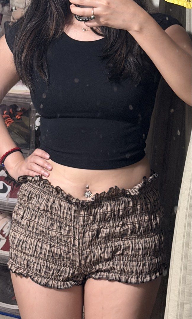 Checkered smocked ruffle shorts (Category: Shorts) located in Manila. Submitted by backupaccount2 (Listing ID 1469696897, Image 1). Description: - Trendy brown and black checkered pattern - All-over smocked texture with cute ruffle trim at waistband and hems - Super stretchy and breathable fabric for an ultra-comfy fit - Flattering mid-rise style with a short length - Versatile casual piece, great for lounging or running errands - Ships immediate