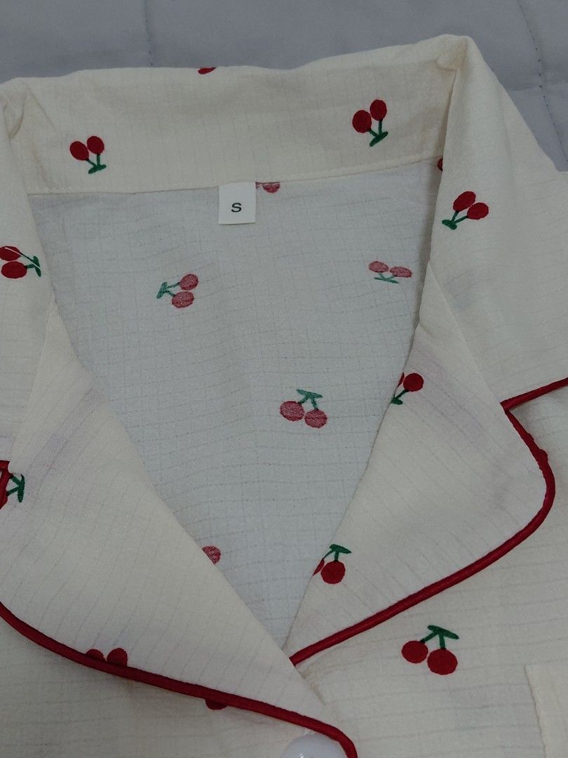 Cherry Print Short Sleeve Pajama Set Size S (Category: Undergarments & Loungewear) located in Taguig. Submitted by ynelshop (Listing ID 1469690701, Image 3). Description: - Style: Cute cherry print pajama set in cream with red piping - Top: Short-sleeve, button-down with a convenient chest pocket - Bottoms: Matching shorts featuring a comfortable elastic waistband - Size: S - Material: Lightweight, soft, and breathable fabric ideal for sleeping o