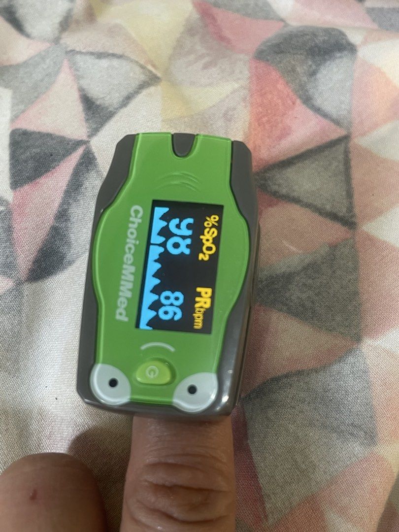 ChoiceMMed Pediatric Frog Pulse Oximeter (Category: Medical Supplies & Tools) located in Manila. Submitted by mdeclutter_mnl (Listing ID 1469617098, Image 3). Description: ChoiceMMed pediatric pulse oximeter shaped like a green frog. Finger-insert design with a digital screen displaying oxygen saturation percentage and pulse rate in beats per minute. Power button under the frog face. Includes protective plastic case. Original price: 1,300++ Rfs: 