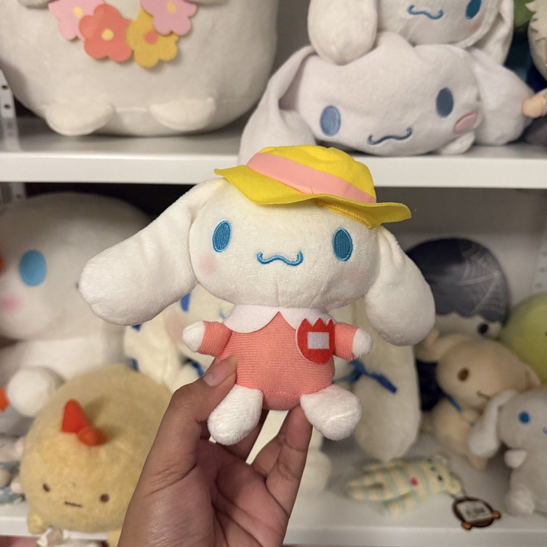 Cinnamoroll Kindergarten Mascot Plushie (Category: Plushies & Soft Toys) located in Taguig. Submitted by exidofficial (Listing ID 1469744844, Image 1). Description: - Authentic small Cinnamoroll plush figure - Wears an adorable yellow sun hat with a pink band and pink collared dress with a red heart badge - Features signature big blue embroidered eyes, pink cheeks, and soft white floppy ears - Made from super soft fabric material - Super clean co
