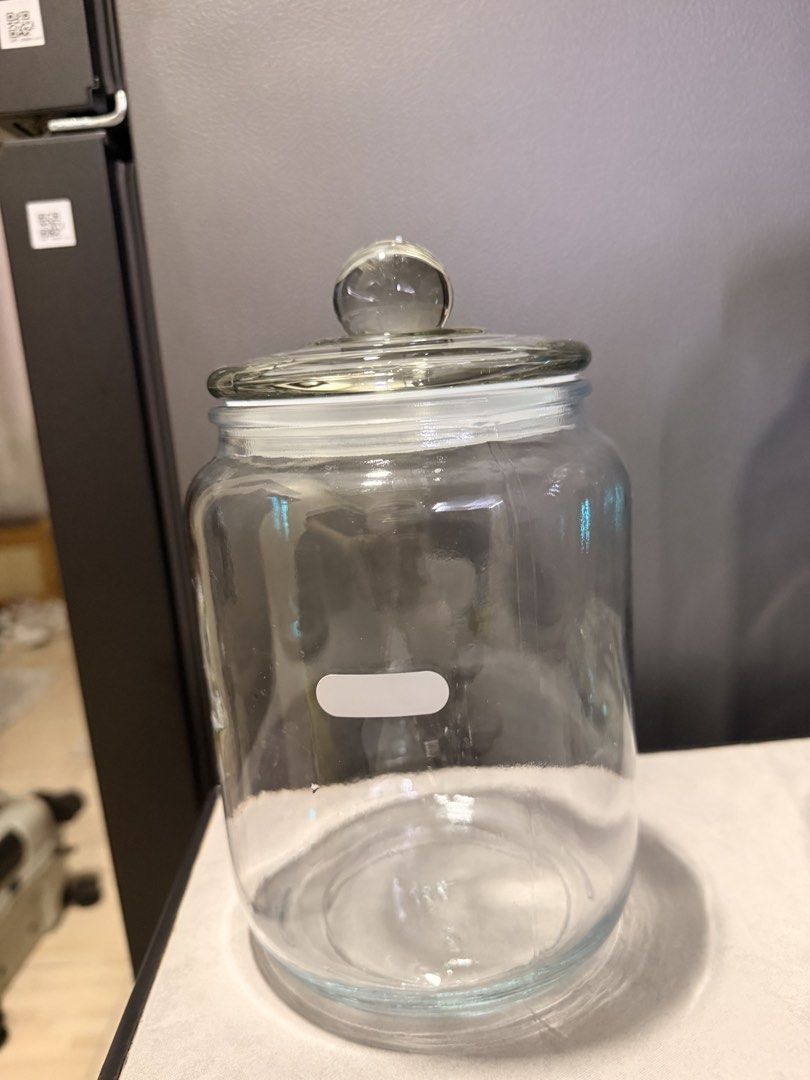 Clear Glass Storage Jar with Lid (Category: Food Organization & Storage) located in Mandaluyong City. Submitted by riz_040521 (Listing ID 1469592470, Image 2). Description: - Clear glass jar with matching lid and knob top - Airtight rubber seal keeps contents fresh - Features a blank white label on the front for easy content labeling - Heavy and thick glass construction for durability - Clean inside and out, ready for use - Ideal for kitchen pant