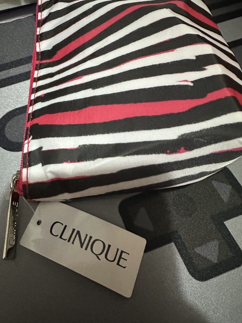 Clinique Striped Cosmetic Pouch Makeup Bag (Category: Purses & Pouches) located in Manila. Submitted by lunalux09 (Listing ID 1469717757, Image 2). Description: - 100% Authentic Clinique cosmetic pouch - Stylish black, white, and pink vertical stripe exterior - Vibrant pink interior lining with a roomy space for makeup and essentials - Secure pink zipper closure featuring a custom branded metal pull - Brand new with attached Clinique product tag 