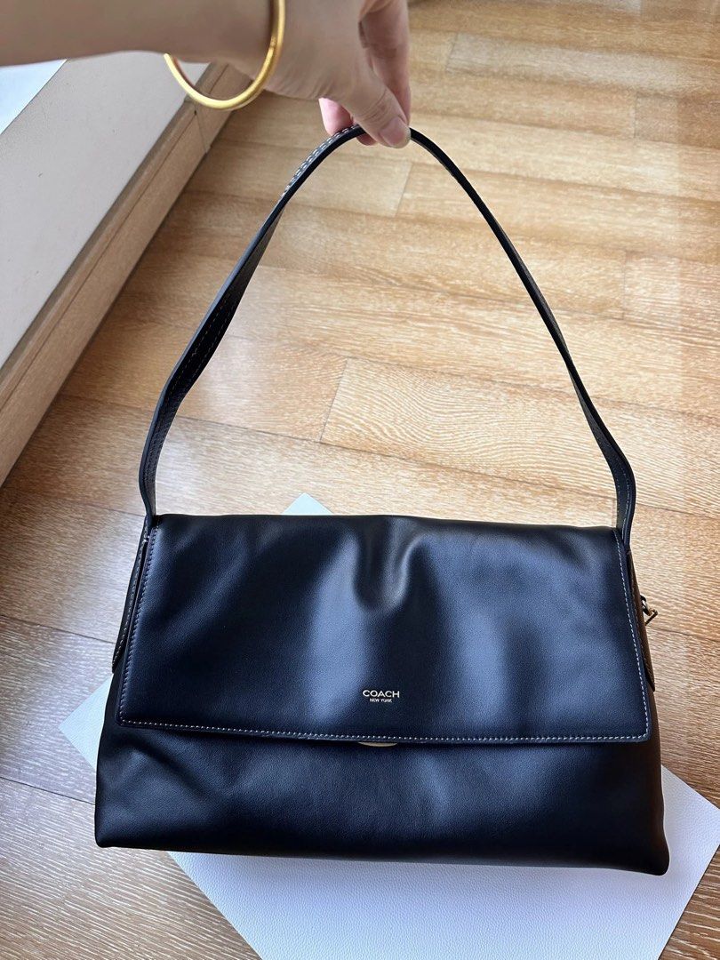 Coach Black Leather Shoulder Bag (Category: Luxury Bags & Wallets) located in Manila. Submitted by randomreps (Listing ID 1469677905, Image 1). Description: - - Sleek flap closure accented with gold-toned hardware lettering - Includes signature matching leather hangtag - Clean minimalist design highlighted by stylish contrast stitching - Spacious interior with plenty of room for daily essentials - Classic everyday purse, perfect for any outfit.