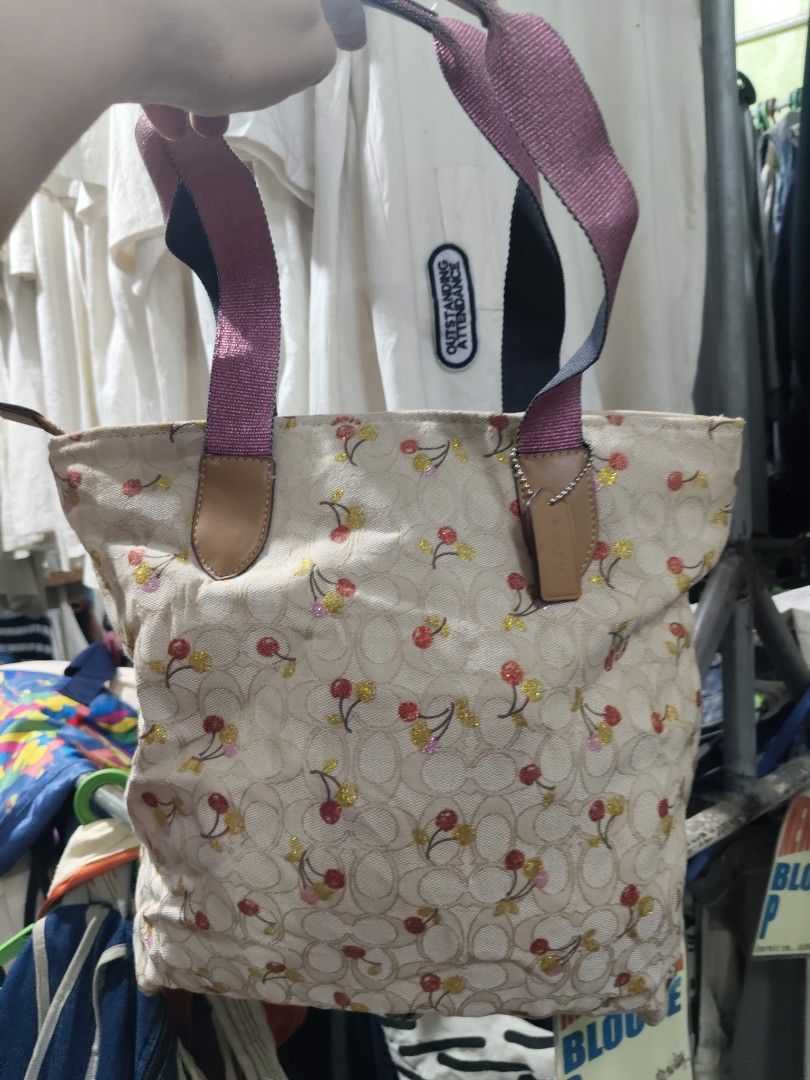 Coach Cherry Print Tote Bag Cream (Category: Tote Bags) located in Manila. Submitted by cosmicgem.54b13d (Listing ID 1469600202, Image 3). Description: - Authentic Coach tote bag in cream - Cute all-over cherry pattern with glitter details - Secure zip-top closure - Sturdy fabric handles and pink shoulder straps - Spacious brown fabric-lined interior with Coach tag - Roomy enough for all your daily essentials.