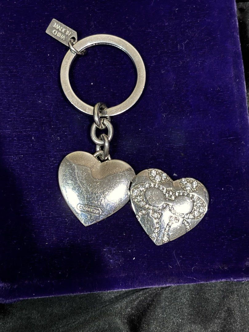 Coach Heart Locket Keychain Ring Silver Rhinestones (Category: Luxury Accessories) located in Caloocan City. Submitted by berndale_closet (Listing ID 1469587536, Image 3). Description: - Brand: Coach - Design: Silver-tone heart locket with crystal rhinestone bow pattern - Feature: Opens up to hold tiny photos inside - Inclusion: Small Coach hangtag attached to split ring and protective grey display box - Condition: Brand new with box - Perfect as