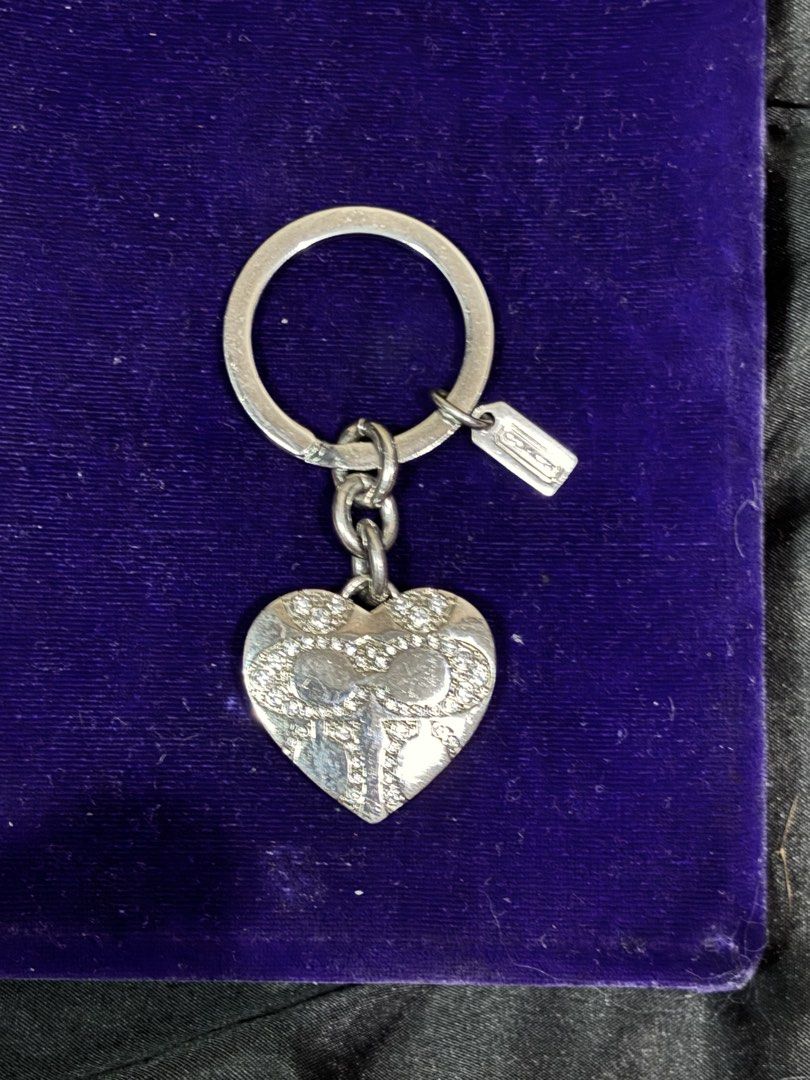 Coach Heart Locket Keychain Ring Silver Rhinestones (Category: Luxury Accessories) located in Caloocan City. Submitted by berndale_closet (Listing ID 1469587536, Image 1). Description: - Brand: Coach - Design: Silver-tone heart locket with crystal rhinestone bow pattern - Feature: Opens up to hold tiny photos inside - Inclusion: Small Coach hangtag attached to split ring and protective grey display box - Condition: Brand new with box - Perfect as
