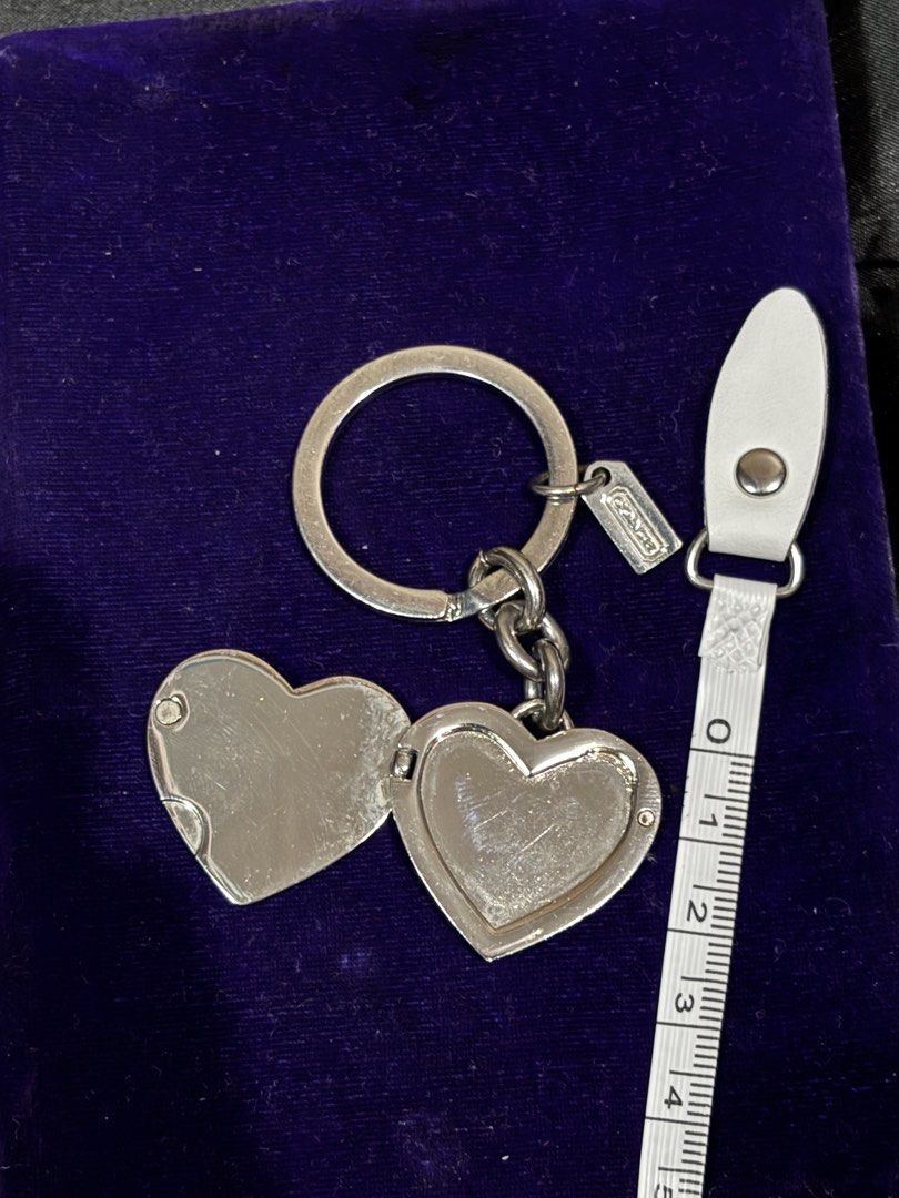 Coach Heart Locket Keychain Ring Silver Rhinestones (Category: Luxury Accessories) located in Caloocan City. Submitted by berndale_closet (Listing ID 1469587536, Image 2). Description: - Brand: Coach - Design: Silver-tone heart locket with crystal rhinestone bow pattern - Feature: Opens up to hold tiny photos inside - Inclusion: Small Coach hangtag attached to split ring and protective grey display box - Condition: Brand new with box - Perfect as