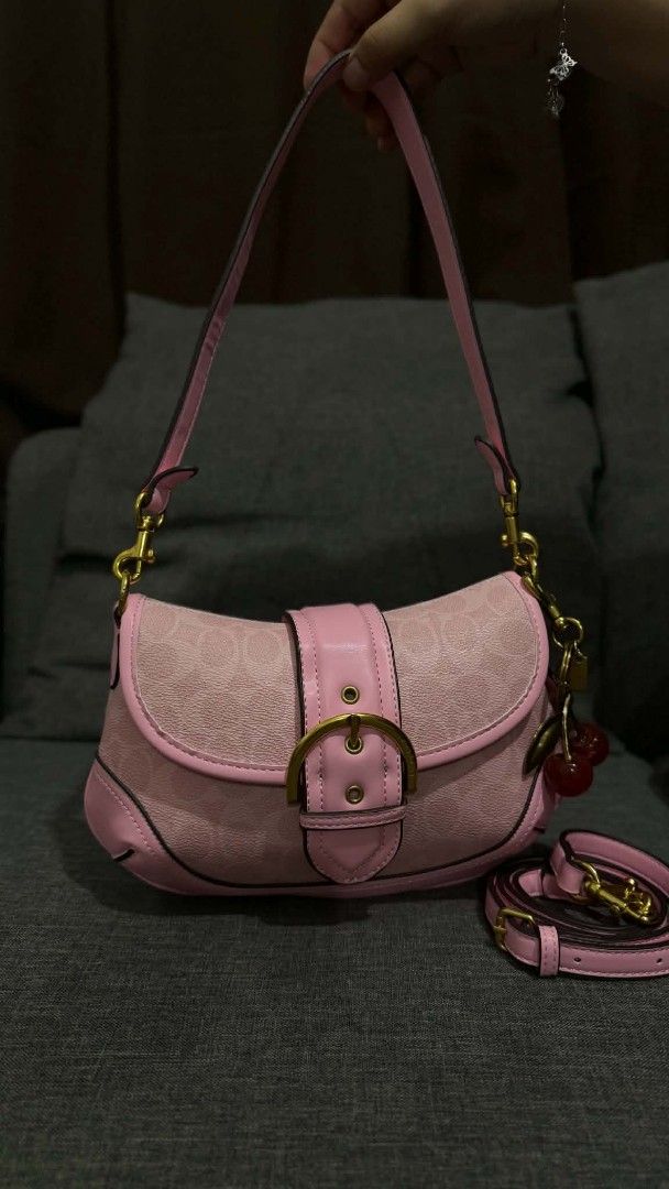 Coach Pink Signature Shoulder Bag (Category: Luxury Bags & Wallets) located in Cavite. Submitted by loriojenni09117 (Listing ID 1469700438, Image 1). Description: - Brand: Coach - Color: Light pink signature canvas with gold-tone hardware - Straps: Includes a short handle and a removable matching shoulder strap - Accent: Adorable cherry charm attached to the side ring - Interior: Brown fabric lining with a secure zipper pocket and classic story p