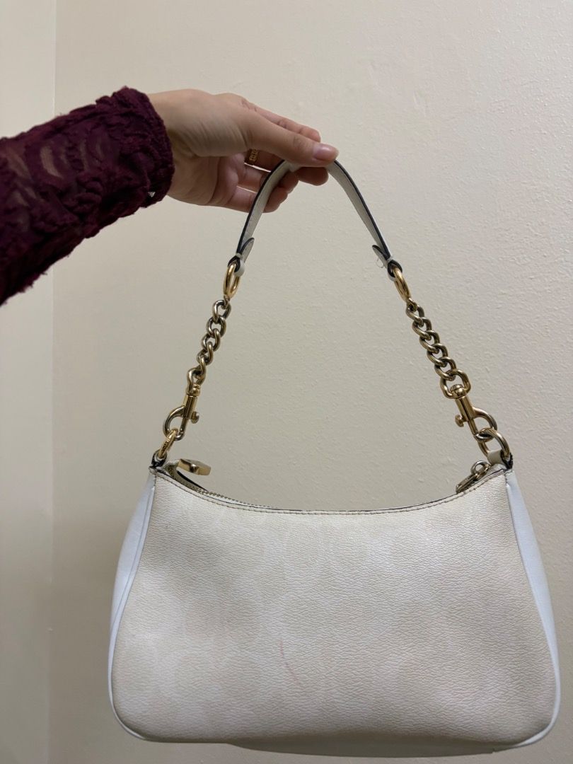 Coach White Leather Shoulder Bag (Category: Luxury Bags & Wallets) located in Quezon City. Submitted by silentstar.3e0b05 (Listing ID 1469612896, Image 2). Description: - Brand: Coach - Color: Classic White with luxurious gold-tone hardware - Material: Premium leather featuring a subtly embossed monogram pattern - Strap: Elegant chain-link detail for a chic look - Closure: Secure zip-top closure to keep your belongings safe - Interior: Clean lini