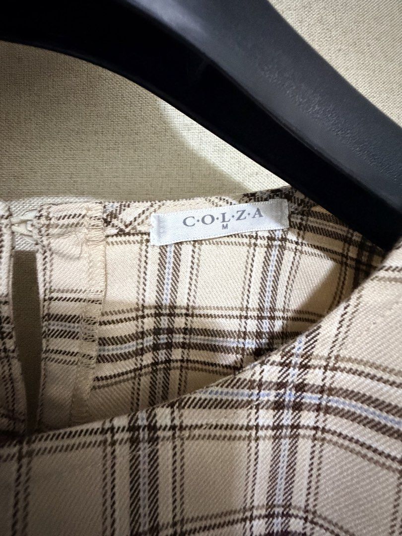 COLZA Plaid Ruffle Long Sleeve Blouse Size M (Category: Longsleeves) located in Cavite. Submitted by mgd.blessed (Listing ID 1469656327, Image 2). Description: - Brand: COLZA - Size: M (tag attached) - Color/Pattern: Beige with brown plaid - Details: Cute ruffle accents across front shoulders, elastic cuffs, and back button closure - Fabric: Lightweight and comfortable - Condition: Great for layering or wearing on its own.