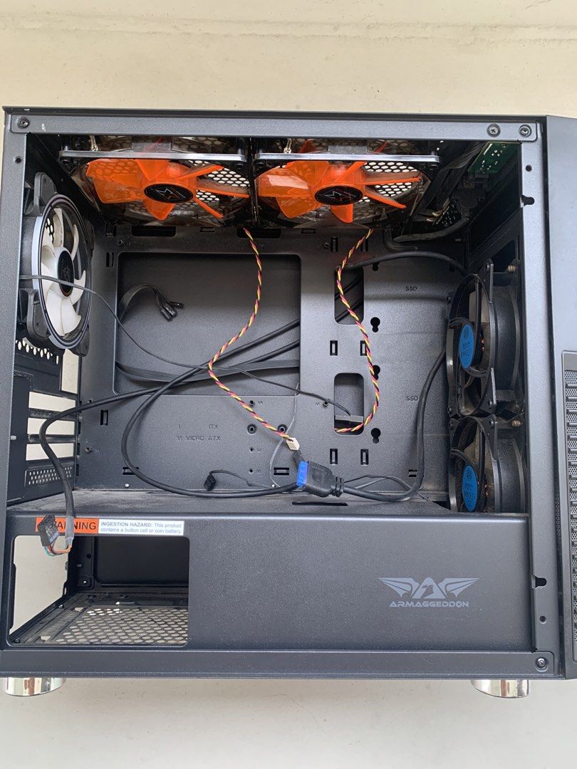 Computer Casing (Category: Desktops) located in Singapore. Submitted by selfcollectfromkhatib (Listing ID 1469641509, Image 2). Description: - Sturdy black computer casing suitable for custom PC builds - Pre-installed with 5 cooling fans: 2x Xigmatek orange fans (top), 2x Cooler Master fans (side), and 1x RGB fan (rear) - Front panel features cool gaming and tech stickers (ROG, Razer, etc.) - Good condition, ready for your motherboard and compone