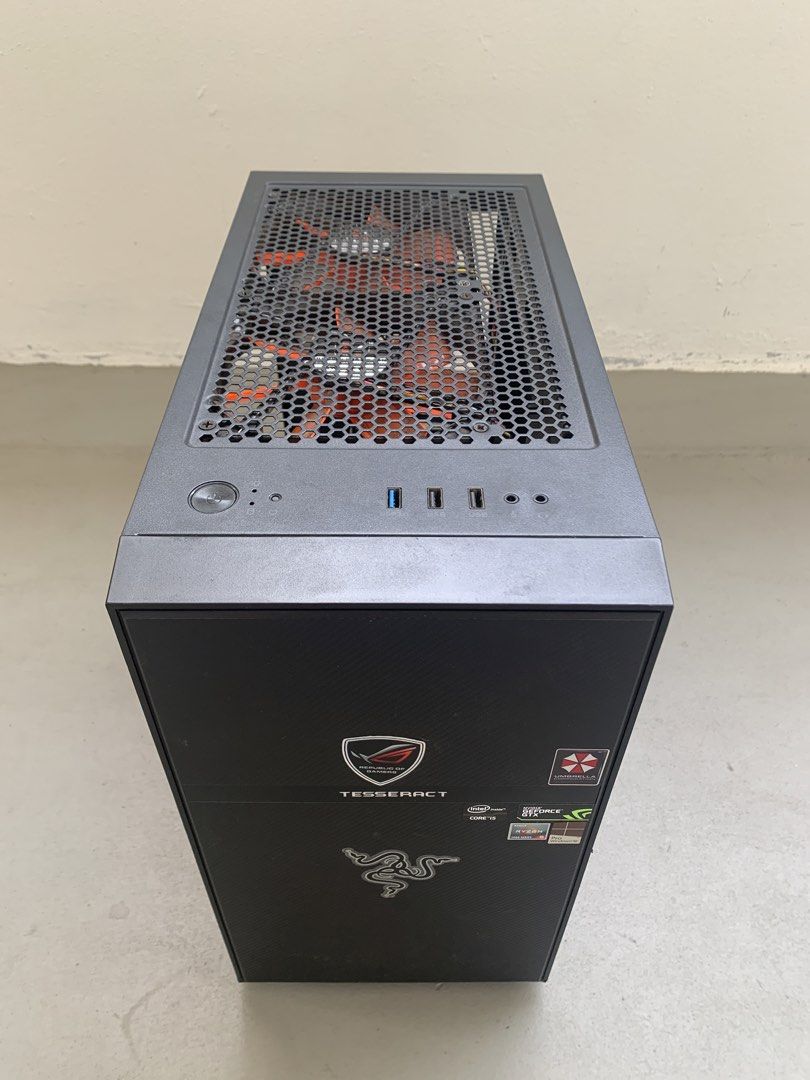 Computer Casing (Category: Desktops) located in Singapore. Submitted by selfcollectfromkhatib (Listing ID 1469641509, Image 1). Description: - Sturdy black computer casing suitable for custom PC builds - Pre-installed with 5 cooling fans: 2x Xigmatek orange fans (top), 2x Cooler Master fans (side), and 1x RGB fan (rear) - Front panel features cool gaming and tech stickers (ROG, Razer, etc.) - Good condition, ready for your motherboard and compone