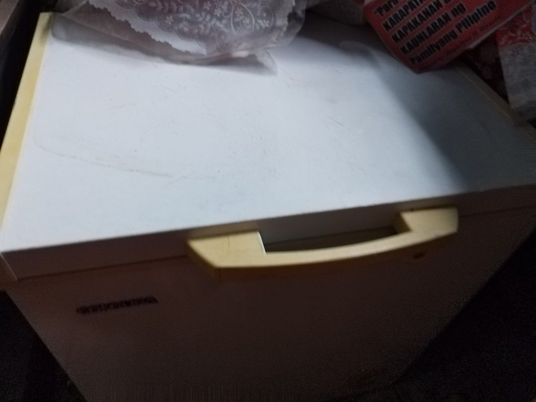 Condura Chest Freezer (Category: Refrigerators and Freezers) located in Makati City. Submitted by nerydevera (Listing ID 1469756667, Image 2). Description: - Brand/Model: Condura chest freezer - Condition: Fully working with minor signs of regular use - Exterior: White body with a yellowish handle and integrated lock - Interior: Deep storage space with a convenient removable wire storage basket - Perfect for: Extra food storage at home.