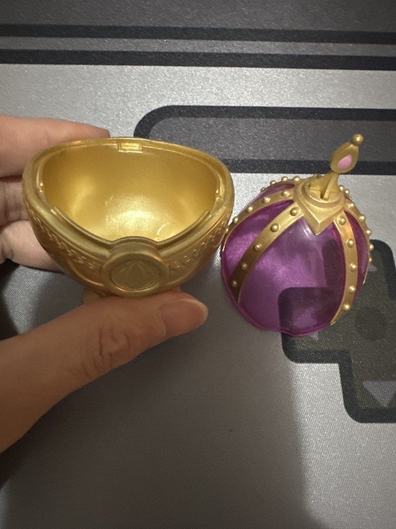 Container Figure Toy gacha from japan (Category: Figurines & Statues) located in Manila. Submitted by lunalux09 (Listing ID 1469720396, Image 2). Description: - Official-style Madoka Magica Grief Seed container collectible - Features an ornate gold base and translucent pink upper section - Removable top piece included - Stands upright securely on a small circular pedestal - Clean condition, inside and out - Exact measurements shown in pictures.