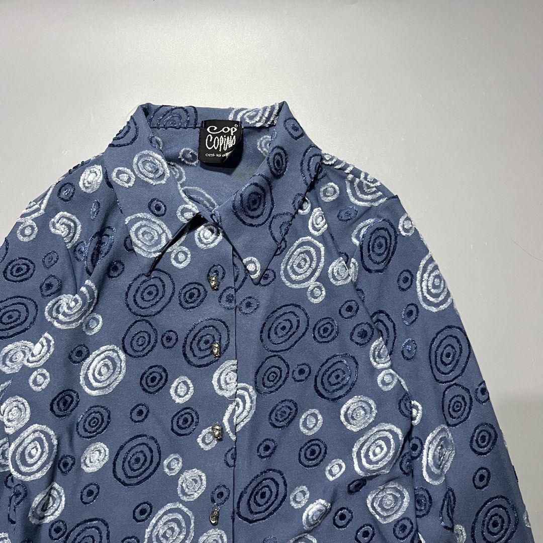 Cop Copine Blue Swirl Pattern Long Sleeve Button Up Shirt (Category: Longsleeves) located in Iloilo. Submitted by kahit.ano.na.lang (Listing ID 1469736989, Image 2). Description: - Brand: Cop Copine (Vintage) - Color: Dusty blue - Design: Textured swirl and spiral pattern throughout - Details: Classic collar neckline, unique metallic face buttons - Fabric: Soft, stretchy material for a comfortable fit - Condition: Great vintage piece.