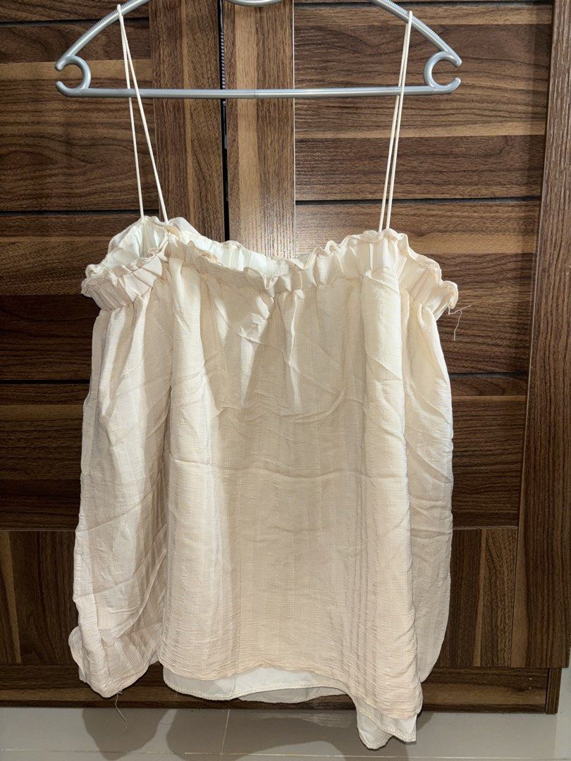 Cream spaghetti strap ruffled top (Category: Sleeveless) located in Manila. Submitted by bellsellsss (Listing ID 1469597890, Image 1). Description: - Color: Cream - Style: Spaghetti strap top with a cute ruffled neckline - Fit: Loose, flowy, and breathable for warm weather - Features: Fully lined with thin adjustable shoulder straps - Condition: Good, just needs a quick iron from storage - Versatility: A simple, easy-to-match basic piece for ever