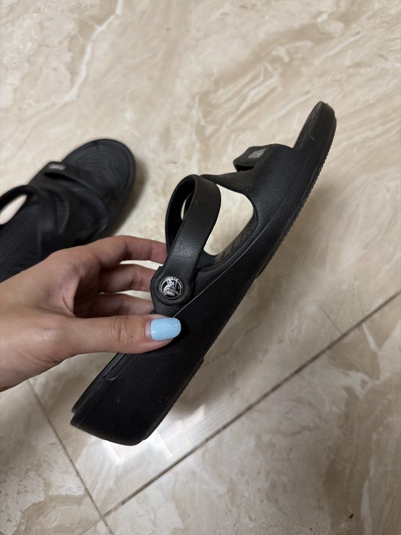 Crocs Black Sandals W7 (Category: Sandals) located in Paranaque City. Submitted by TrendyBoutique.ph (Listing ID 1469667102, Image 3). Description: - Brand/Item: Black Crocs sandals - Size: Women's W7 (US) - Design: Slip-on with double strap upper and metallic logo badge - Comfort & Safety: Textured footbed for better grip - Condition: Durable rubber outsole with minimal wear on the tread - Care: Easy to clean, ideal for everyday casual use.