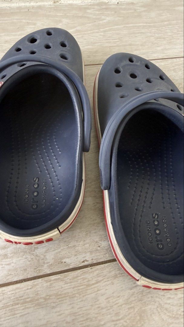 Crocs Crocband Clogs Navy Blue Size C11 (Category: Babies & Kids Fashion) located in Taguig. Submitted by closet_shoppe (Listing ID 1469757815, Image 3). Description: - Authentic Navy Blue Crocs Crocband Clogs - Size: C11 (stamped on outsole) - Design: Classic navy upper with iconic white and red midsole stripes and side logo badge - Comfort: Features signature ventilation holes and Iconic Crocs Comfort footbed - Condition: Shows regular signs of