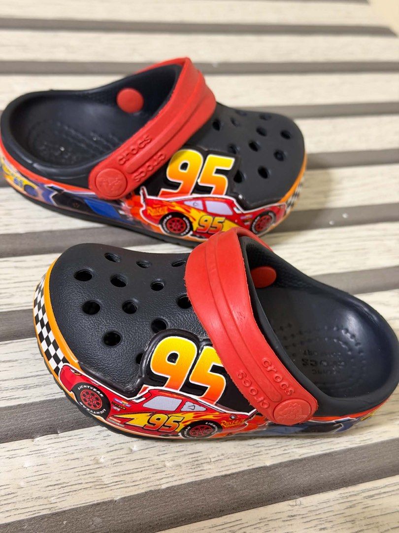 Crocs Lightning McQueen Kids Clogs Size C4 (Category: Babies & Kids Fashion) located in Manila. Submitted by bizfits_ (Listing ID 1469618473, Image 1). Description: - Authentic Disney Cars Lightning McQueen design with number 95 graphics - Color: Black with bright red heel strap and yellow accents - Features ventilation holes on top for breathability - Easy slip-on style perfect for kids - Clear sizing info on the bottom sole - Condition: [Insert