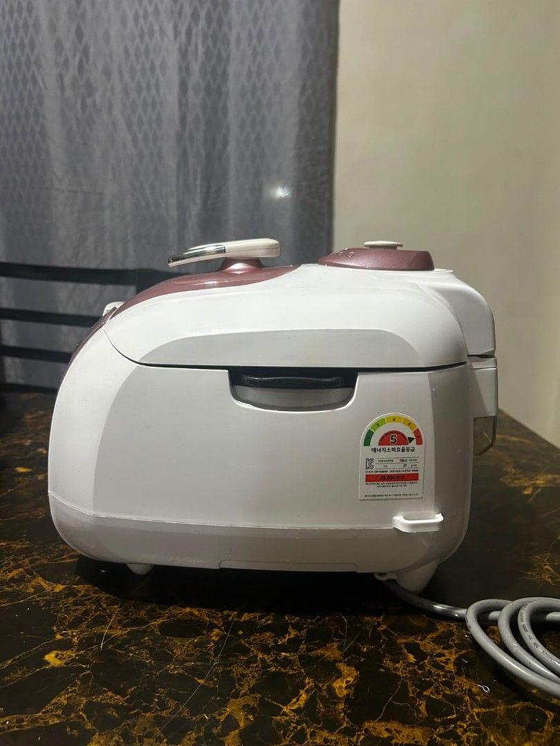 Cuckoo Electric Pressure Rice Cooker (Category: Cookers) located in Taguig. Submitted by lhadychinitah (Listing ID 1469680180, Image 2). Description: - Brand: Cuckoo Electric Pressure Rice Cooker - Model: CRP-FA0661SP - Origin: Made in Korea - Color: White with pinkish-brown accents - Condition: Pre-owned, well-maintained and fully functional - Features: Digital display panel, pressure lock mechanism, and removable water collection tray at the ba