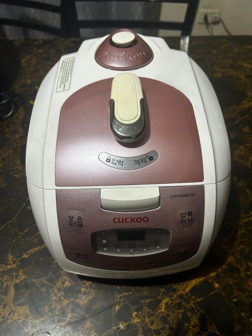 Cuckoo Electric Pressure Rice Cooker (Category: Cookers) located in Taguig. Submitted by lhadychinitah (Listing ID 1469680180, Image 3). Description: - Brand: Cuckoo Electric Pressure Rice Cooker - Model: CRP-FA0661SP - Origin: Made in Korea - Color: White with pinkish-brown accents - Condition: Pre-owned, well-maintained and fully functional - Features: Digital display panel, pressure lock mechanism, and removable water collection tray at the ba