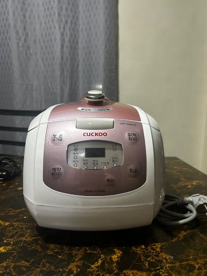 Cuckoo Electric Pressure Rice Cooker (Category: Cookers) located in Taguig. Submitted by lhadychinitah (Listing ID 1469680180, Image 1). Description: - Brand: Cuckoo Electric Pressure Rice Cooker - Model: CRP-FA0661SP - Origin: Made in Korea - Color: White with pinkish-brown accents - Condition: Pre-owned, well-maintained and fully functional - Features: Digital display panel, pressure lock mechanism, and removable water collection tray at the ba