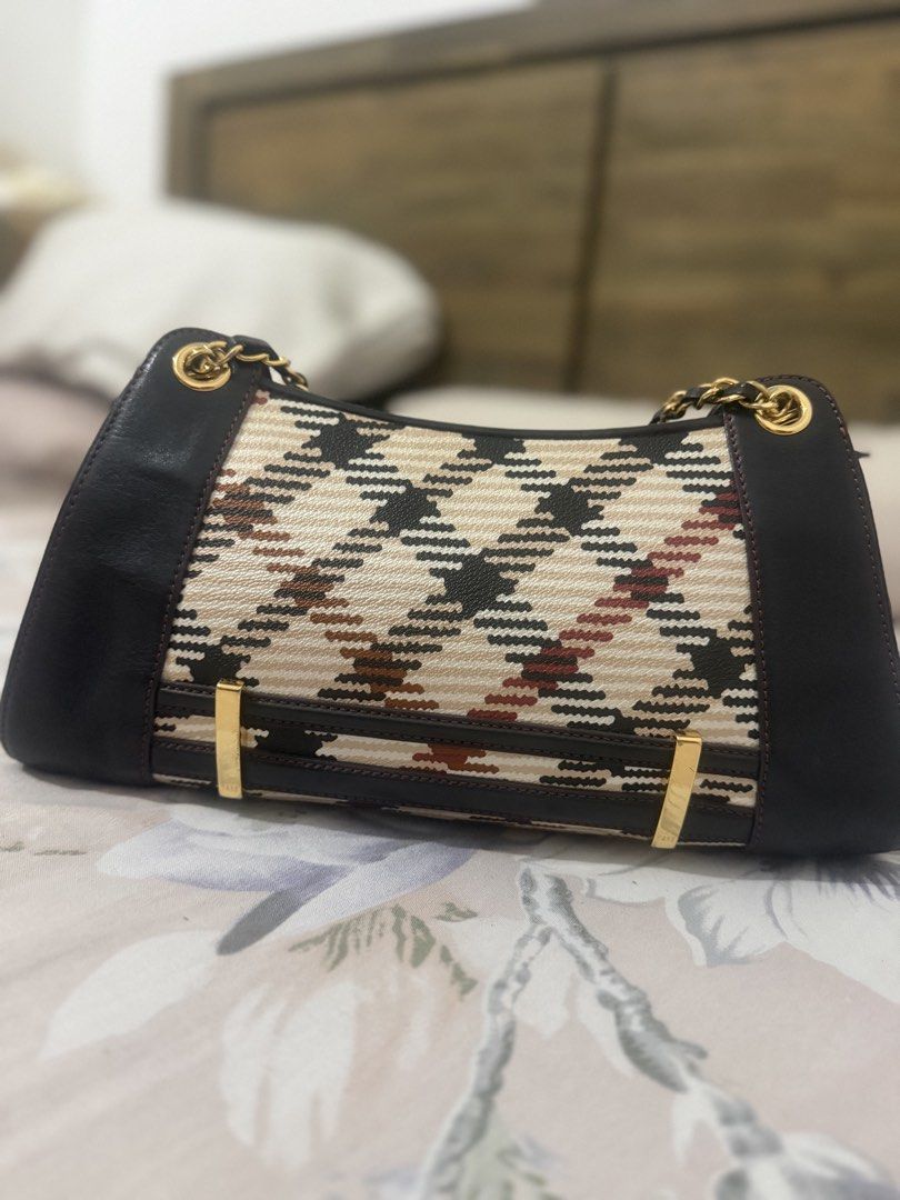 DAKS Houndstooth Pattern Shoulder Handbag with Gold Chains (Category: Luxury Bags & Wallets) located in Manila. Submitted by maambeeeeyah (Listing ID 1469661004, Image 2). Description: - Brand: DAKS - Pattern: Classic houndstooth in cream, black, and brown - Material: Woven fabric with dark leather trim - Hardware: Gold-tone accents and chain straps - Closure: Top zip with DAKS branded zipper pull - Structure: Structured bottom and clean side pro