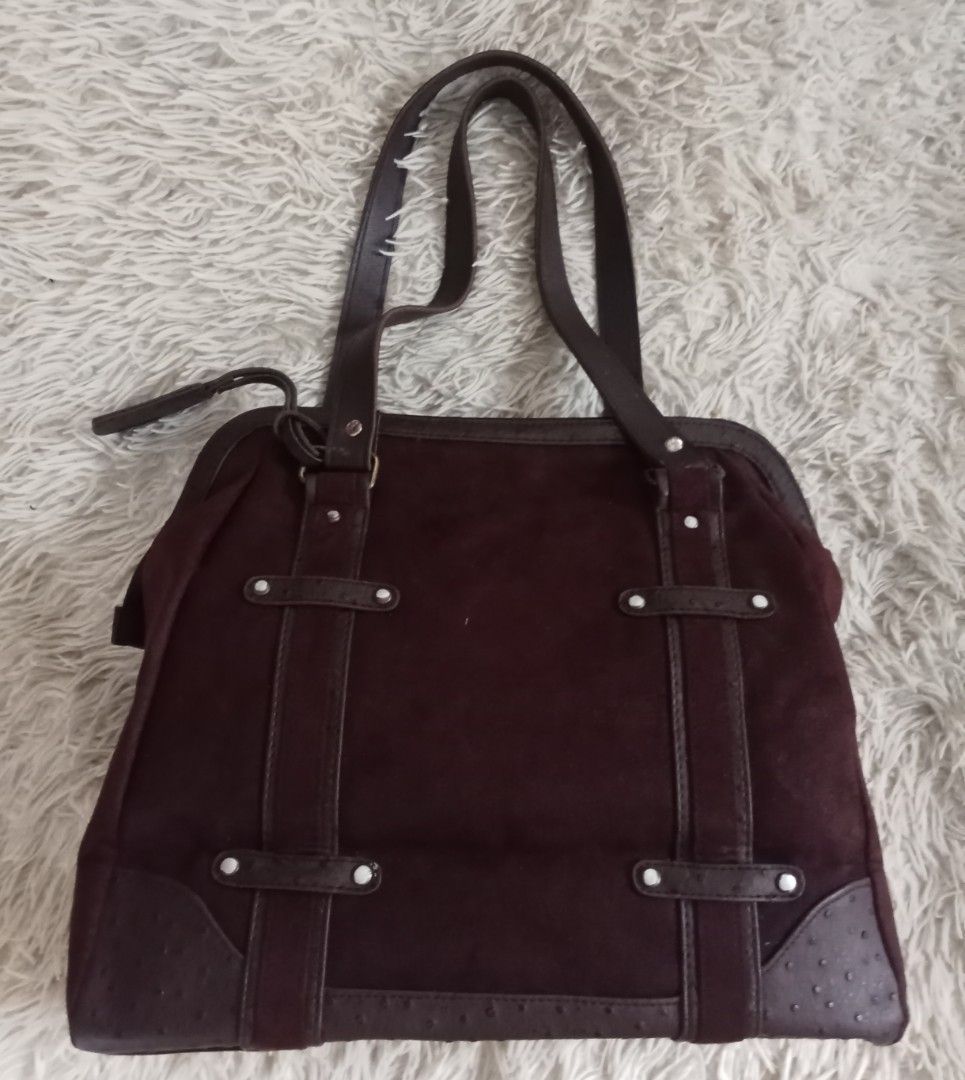 Dark brown suede tote bag with textured straps (Category: Tote Bags) located in Caloocan City. Submitted by noy5o1a (Listing ID 1469636790, Image 1). Description: - Dark brown suede tote bag with structured silhouette - Textured faux ostrich leather trim on base, corners, and handles - Secure zip-top closure - Double shoulder straps for comfortable carry - Accented with horizontal/vertical straps and silver-tone studs - Includes a matching decora