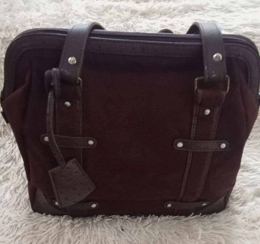 Dark brown suede tote bag with textured straps (Category: Tote Bags) located in Caloocan City. Submitted by noy5o1a (Listing ID 1469636790, Image 3). Description: - Dark brown suede tote bag with structured silhouette - Textured faux ostrich leather trim on base, corners, and handles - Secure zip-top closure - Double shoulder straps for comfortable carry - Accented with horizontal/vertical straps and silver-tone studs - Includes a matching decora