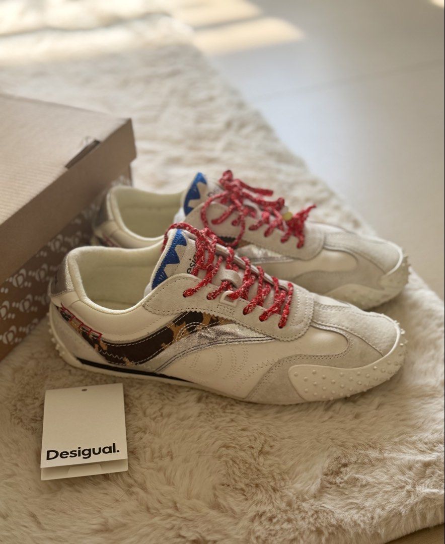 Desigual Retro Sneaker Heritage Patch EUR 39 authentic (Category: Sneakers) located in Manila. Submitted by sanmer25 (Listing ID 1469579805, Image 2). Description: - Brand: Desigual - Style: Retro sneakers with heritage patches and animal print side stripe - Color: Off-white with red patterned laces (beaded ends), blue jagged tongue trim, and silver metallic heel accents - Size: EUR 39 / US 8 / UK 6 - Sole: Textured rubber - Inclusions: Original 