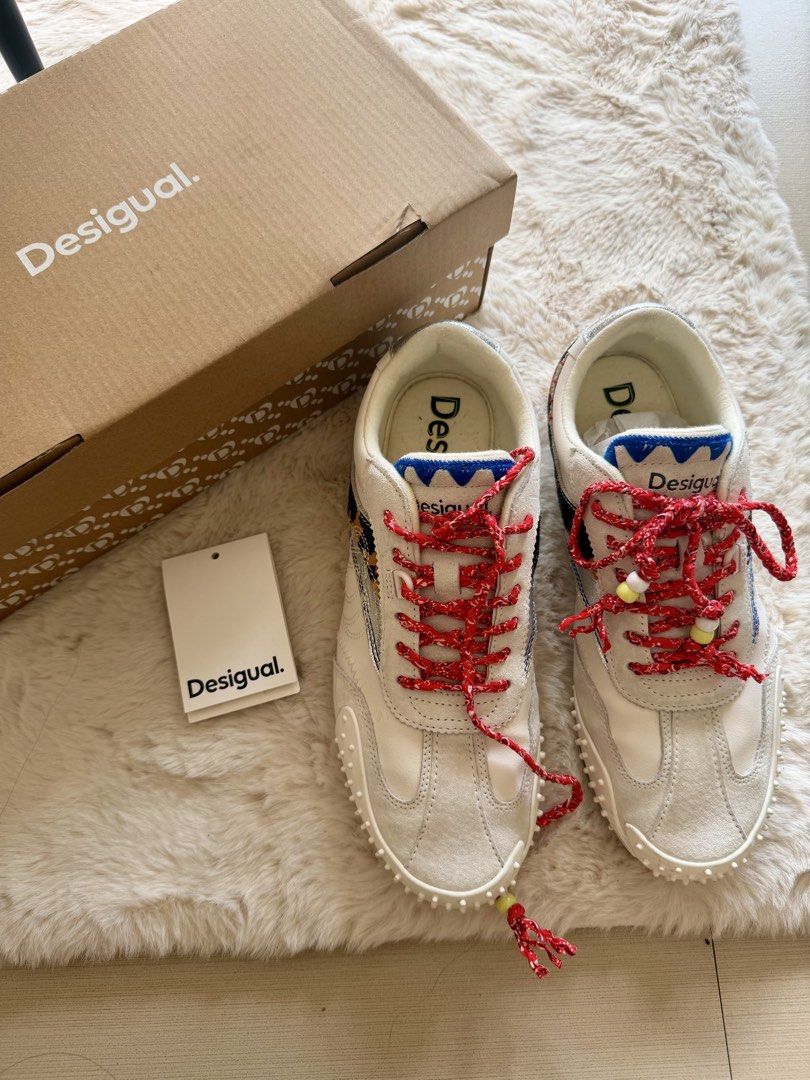 Desigual Retro Sneaker Heritage Patch EUR 39 authentic (Category: Sneakers) located in Manila. Submitted by sanmer25 (Listing ID 1469579805, Image 1). Description: - Brand: Desigual - Style: Retro sneakers with heritage patches and animal print side stripe - Color: Off-white with red patterned laces (beaded ends), blue jagged tongue trim, and silver metallic heel accents - Size: EUR 39 / US 8 / UK 6 - Sole: Textured rubber - Inclusions: Original 