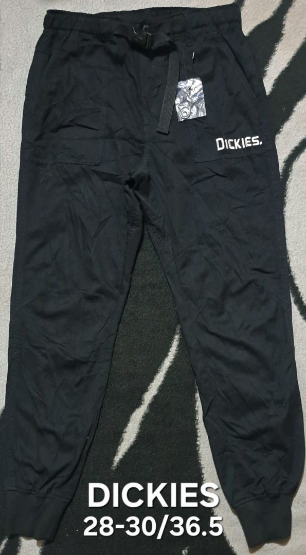 Dickies Black Jogger Pants Size M (Category: Joggers) located in San Fernando, Camarines Sur. Submitted by ladderaya (Listing ID 1469642761, Image 1). Description: - Brand: Dickies - Color: Black - Size: M (fits 28-30 waist, 36.5" length) - Material: 65% polyester, 35% cotton - Features: Elastic waistband with integrated buckle belt, ribbed ankle cuffs, and Dickies logo near the pocket - Condition: Brand new with extra button included inside.