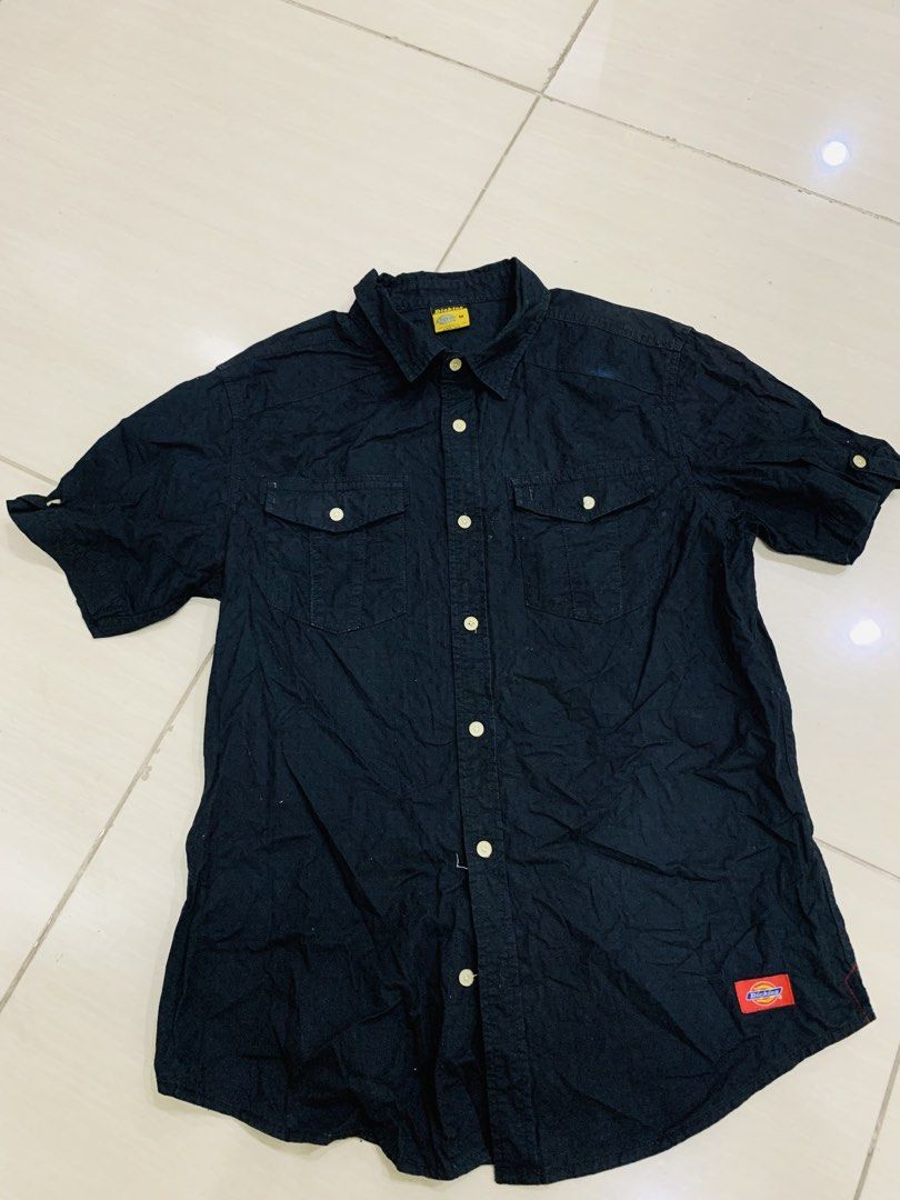 Dickies Black Short Sleeve Button Down Shirt Size M (Category: Tshirts & Polo Shirts ) located in Manila. Submitted by gizmolacaba (Listing ID 1469673087, Image 2). Description: - Brand: Dickies - Color: Solid black - Size: Medium - Style: Short sleeve button-down, classic workwear fit - Details: Dual chest pockets with button flaps and woven logo patch near the hem - Condition: Clean, excellent, ready to wear.