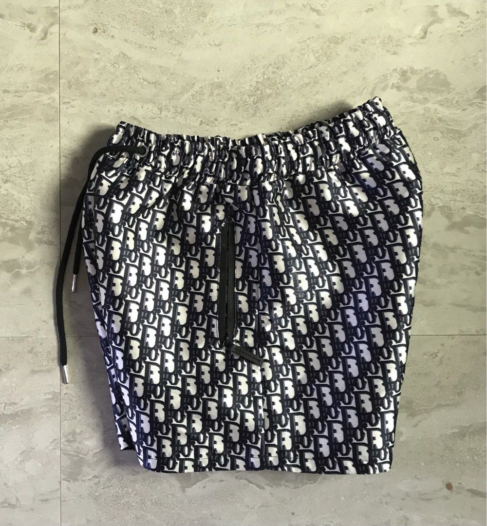 Dior Monogram Shorts Size S (Category: Shorts) located in Banga. Submitted by jorguarino (Listing ID 1469621331, Image 3). Description: - Brand: Dior - Style: Monogram shorts in navy and white - Size: S (tag attached inside) - Fit & Comfort: Elastic waistband with adjustable black drawstrings - Storage: Two front zippered pockets - Condition: Clean overall with a slight smudge mark near the thigh area - Perfect for stylish casual wear.