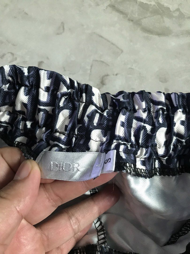 Dior Monogram Shorts Size S (Category: Shorts) located in Banga. Submitted by jorguarino (Listing ID 1469621331, Image 2). Description: - Brand: Dior - Style: Monogram shorts in navy and white - Size: S (tag attached inside) - Fit & Comfort: Elastic waistband with adjustable black drawstrings - Storage: Two front zippered pockets - Condition: Clean overall with a slight smudge mark near the thigh area - Perfect for stylish casual wear.