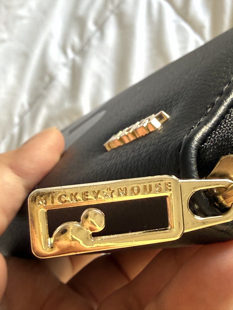 Disney Mickey Mouse Black Long Wallet (Category: Wallets & Card holders) located in Pasig City. Submitted by abbyrds (Listing ID 1469645157, Image 2). Description: - Disney Mickey Mouse zip-around wallet - Material: Premium black polyurethane with chic gold-tone hardware - Cute Mickey-shaped metal zipper pull detail - Interior organization: Multiple card slots, bill compartments, and a secure zippered coin pocket - Condition: Brand new with origi