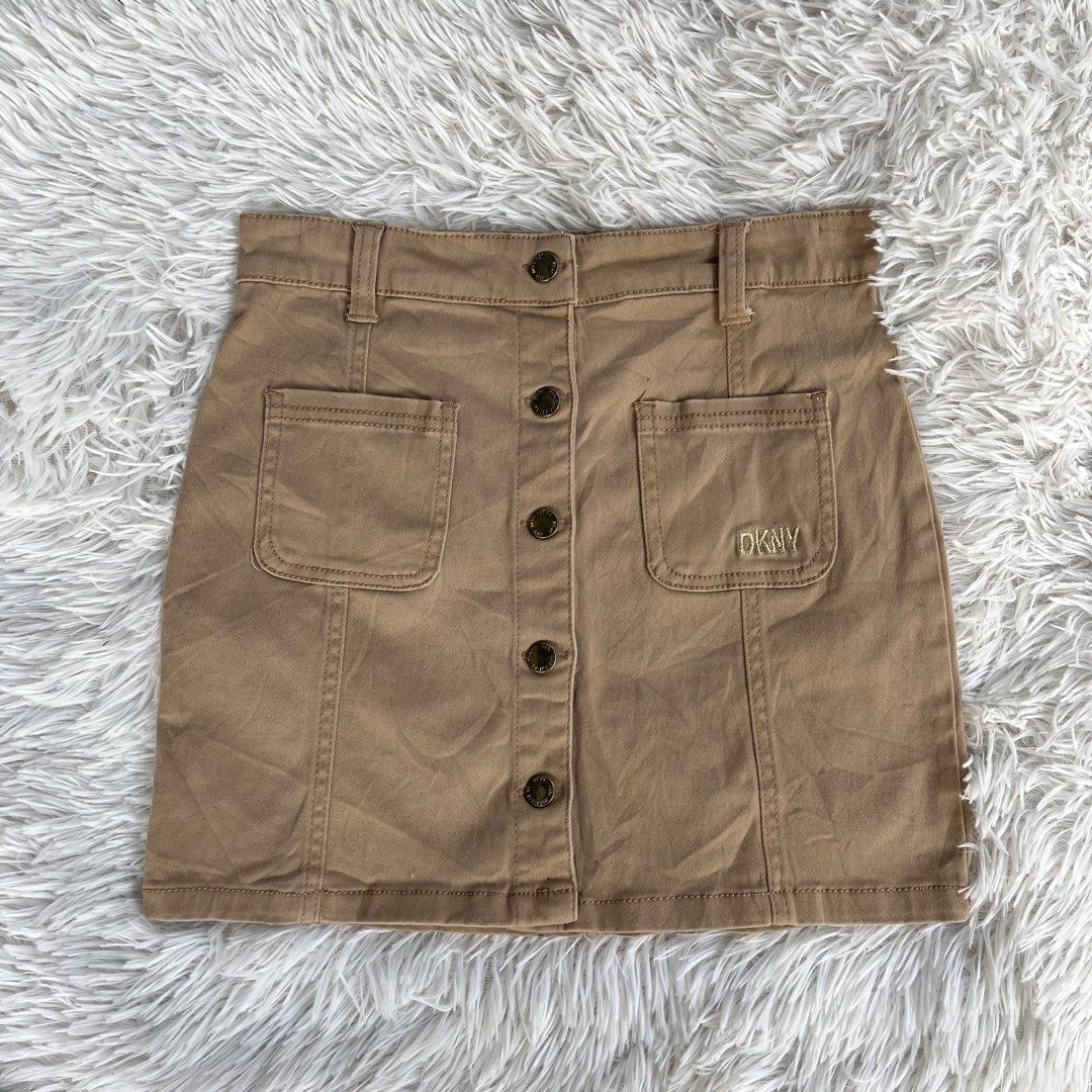 DKNY Brown Button-Front Denim Skirt (Category: Skirts) located in Cuyapo. Submitted by Ashtyn.Pre.Loved (Listing ID 1469622931, Image 2). Description: - Brand: DKNY - Style: Classic A-line denim skirt - Color: Versatile khaki brown - Closure: Front button-down with branded metal hardware - Pockets: Two front patch pockets (with DKNY embroidery) and two back pockets - Details: Belt loops and signature black DKNY brand tag - Condition: Excellent pr