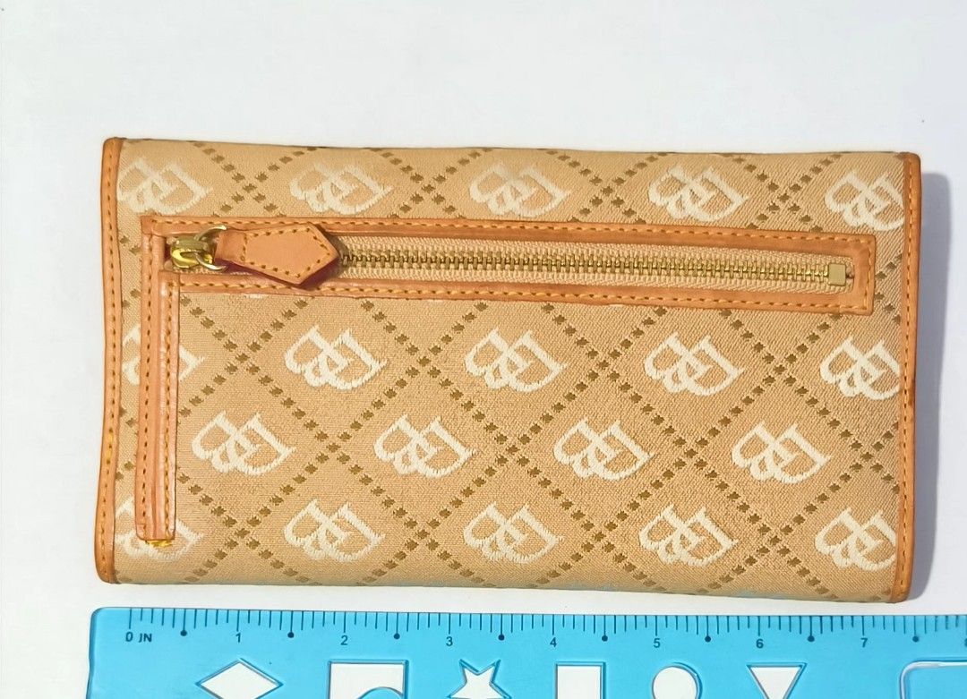 Dooney & Bourke Monogram Canvas Long Flap Wallet Tan (Category: Luxury Bags & Wallets) located in Manila. Submitted by urijahs.preloved (Listing ID 1469611545, Image 2). Description: - Material: Tan monogram canvas with natural leather trim - Closure: Flap closure with iconic metal logo plaque - Exterior: Convenient back zipper pocket for coins or small items - Interior: Multiple card slots, ID window, and spacious cash compartments - Condition: 