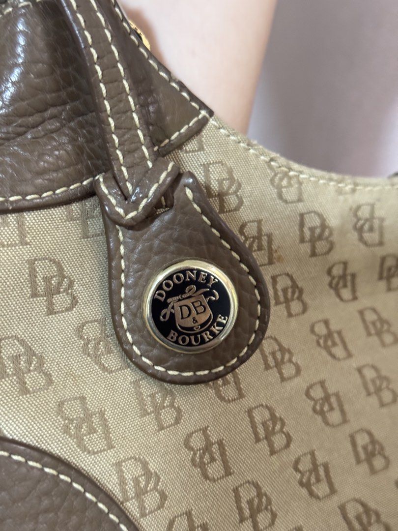 Dooney & Bourke Monogram Shoulder Bag Brown (Category: Luxury Bags & Wallets) located in Tagbilaran City. Submitted by neinjah (Listing ID 1469583086, Image 3). Description: - Authentic Dooney & Bourke shoulder bag - Brown monogram jacquard canvas with all-over DB print - Brown textured leather trim and matching single strap - Secure top zip closure with leather zipper pull - Interior features a zipper pocket and a convenient key leash - Flaw: Ha
